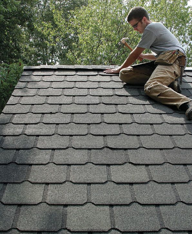a man working on a roof with a hammer